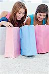 Teenage girls smiling and having a look at shopping bags