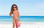 Sourire de petite fille avec des lunettes de soleil sur la plage