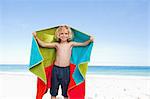 Smiling little boy with towel on the beach