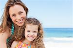 Smiling mother with her daughter on the beach