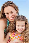 Close up of smiling mother with her daughter on the beach