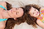 Young mother and daughter relaxing on the beach