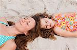Young mother and daughter relaxing on the beach together