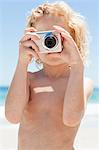 Little boy taking a picture at the beach