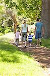 Two children walking with their parents in the park