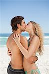 Junges Paar am Strand stehen beim küssen einander