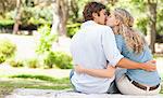 Rear view of a young couple kissing on the grass