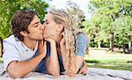 Young couple kissing on the grass