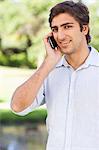 Close up of a smiling young man talking on his mobile phone