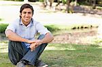 Smiling young man sitting on the lawn