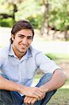 Smiling young man sitting in the park