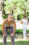 Exhausted young sportswoman waiting for her partner