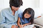 A father helps his daughter do her homework.