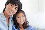 Ein Vater und Tochter gemeinsam auf der Couch sitzen und glücklich lächelnd Hochformat