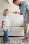 A smiling boy seems to not care what his father is saying to him