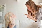 Daughter looks up at her mother as she gets punished