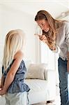 A mother sternly points at her daughter as she corrects her for doing something bad