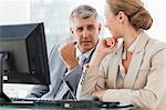 Business people talking in front of a computer in a office