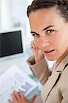 Portrait of a businesswoman with braid working on diagrams in a bright office