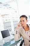 Thoughtful businesswoman in a beige suit in a bright office