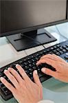 Woman hands typing on a keyboard and a black screen