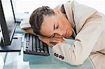 Businesswoman sleeping on her keyboard in a bright office