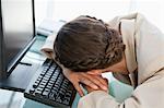 Geschäftsfrau mit Geflecht Kopf auf der Tastatur in einem hellen Büro