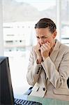 Female in suit with braids worried in a bright office