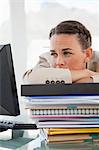 Close-up of a businesswoman with a lot of work in a bright office