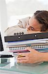 Businesswoman sleeping on a lot of files in a bright office