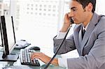 Businessman on the phone at his desk in a bright office