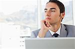 Businessman looking outside in a bright office