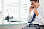 Businessman receiving a good news by phone in a bright office