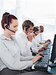 Working young call center employees sitting in a line