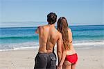 Young couple holding hands while watching the sea