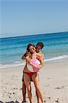 Mann seine Freundin hält ein Strandball mit dem Meer im Backgroung umarmen