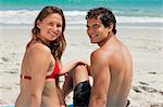 Portrait of a duo sitting on a beach towel in front of the sea