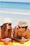 Close-up of a couple being tanning while talking with the sea in background