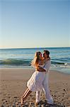 Man swinging his girlfriend in the air on the beach