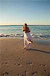 Man swinging his girlfriend on the beach at sunset time