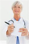 Prescription pad being shown by mature doctor