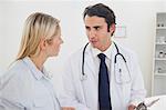 Doctor talking with his female patient in his examination room