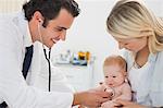 Smiling male doctor measuring little babys heart beat