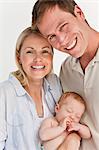 Close up of smiling family against a white background