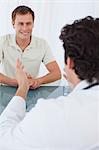 Médecin de sexe masculin parler à son patient souriant