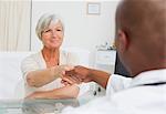 Mature female patient shaking her doctors hand