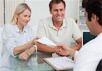 Doctor giving prescription to happy young couple