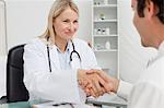 Friendly smiling doctor shaking her patients hand