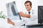 Une radiographie pulmonaire qui s'est tenue par un médecin souriant assis à un bureau