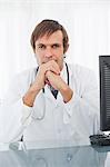 Thoughtful doctor placing his hands in front of his chin